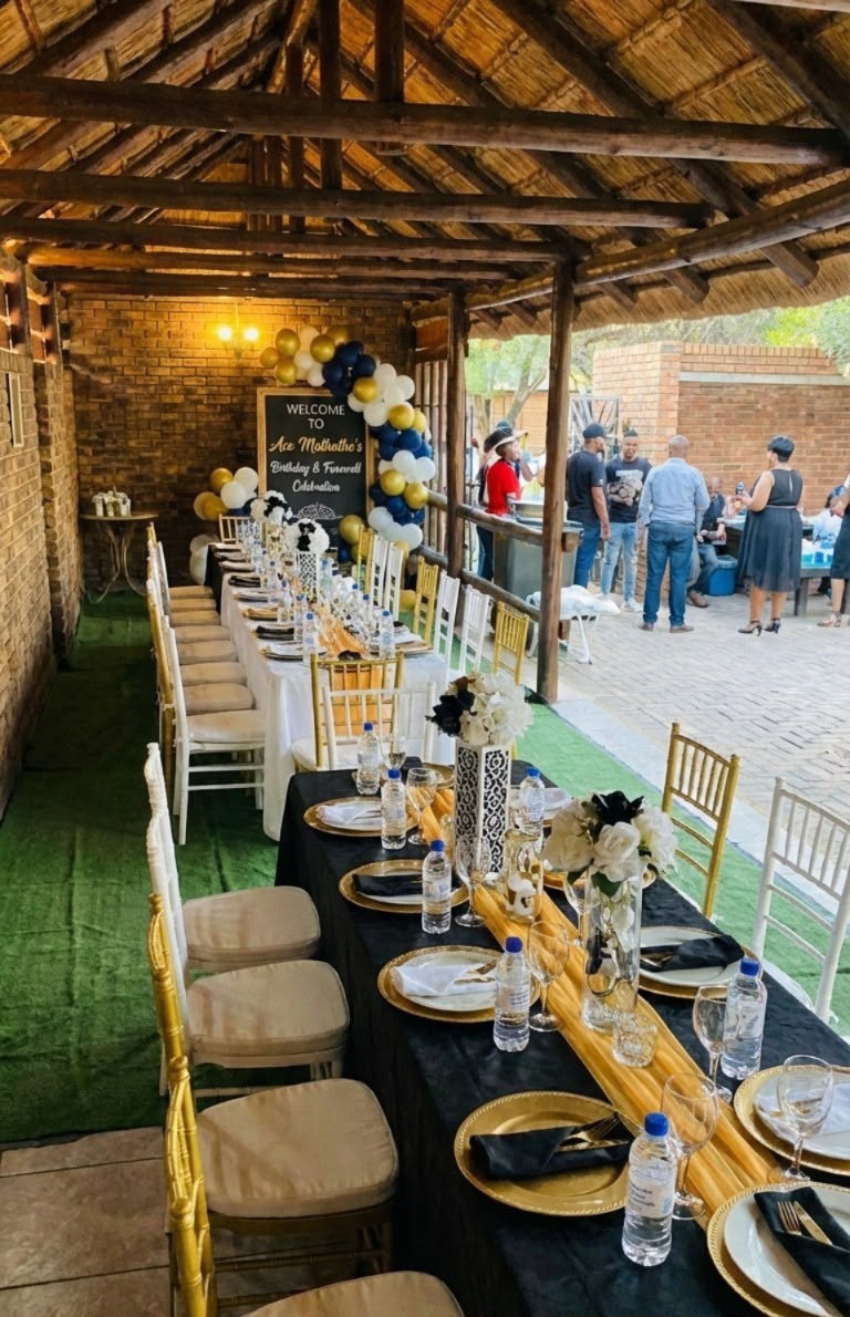 Long banquet table under a thatched lapa with navy, gold and white decor
