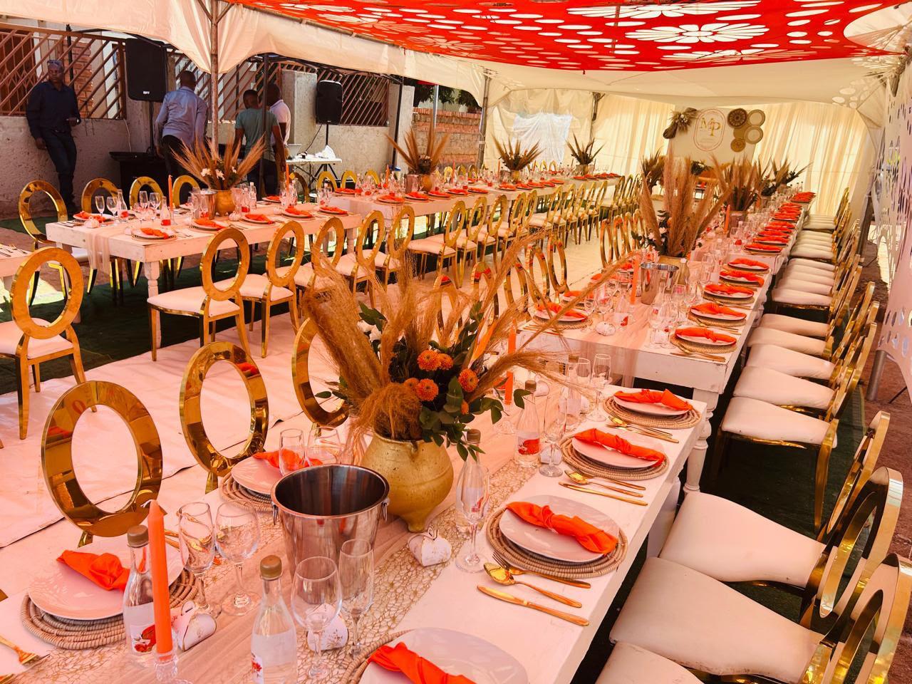Orange and wheat themed tent with long tables and gold chairs